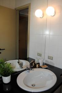 y baño con lavabo y espejo. en Vista Lago Apartment, en Bellagio