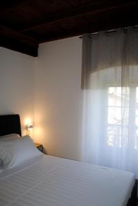 1 dormitorio con cama blanca y ventana en Vista Lago Apartment, en Bellagio