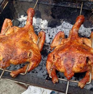 tres pollos están cocinando en una parrilla en Homestay Nang Nghieng, en Kon Tum