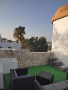 eine Terrasse mit Stühlen und einer Steinmauer in der Unterkunft APARTAMENTO SEGUNDA PLANTA in Chiclana de la Frontera