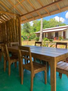 uma mesa de madeira e cadeiras sob uma pérgola em The View Hotel Sigiriya em Sigiriya