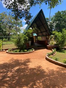 a house with a pavilion in a park at The View Hotel Sigiriya in Sigiriya
