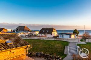 a view of a house with the ocean in the background at Strandhotel Whg20 in Dahme