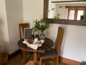 a small table with a vase of flowers and wine glasses at Fox Hill in Brompton