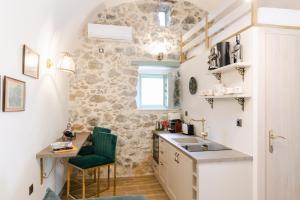 a small kitchen with a sink and a green chair at LA TORE DI MONTENEGRO in Gythio