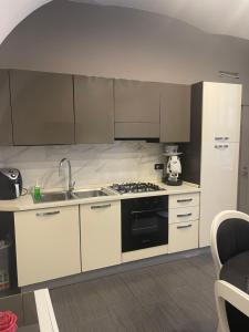 a kitchen with white cabinets and a stove top oven at Plebiscito home in Naples