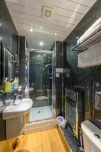 uma casa de banho com um chuveiro, um lavatório e uma banheira em Abbey Guest House em Redcar