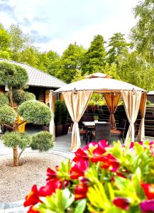 a patio with an umbrella and a table and chairs at Namukas Kunigiškėse in Palanga