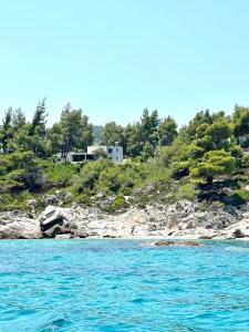 a house on a hill next to a body of water at Dilean luxury villa in Vourvourou