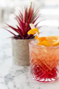a drink on a table with a potted plant at Paros Agnanti Resort & Spa in Parikia
