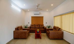 a living room with two couches and a table at Treebo Trend Amigos Residency in Cochin