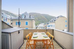 ein Tisch und zwei Stühle auf einem Balkon mit Aussicht in der Unterkunft Appartement Terrasse Vue Montagne in Campan