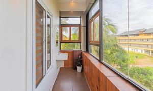 a bathroom with a sink and large windows at Treebo Amigos Residency Cochin Airport Hotel in Cochin
