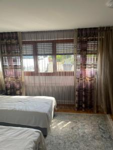 um quarto com 2 camas e uma janela com cortinas em Friebert em Biberach an der Riss