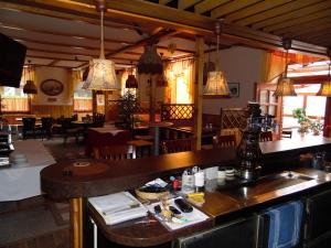 a restaurant with a bar and tables and chairs at Hotel Klappenburg in Hannover