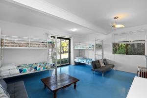 a room with two bunk beds and a table at 19a George Nothling Drive in Point Lookout