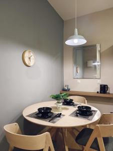 關丹的住宿－Valley Suites by WyattHomes，餐桌、椅子和墙上的时钟
