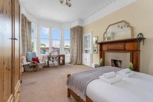 1 dormitorio con 1 cama grande y chimenea en Marchmont Traditional Apartments, en Edimburgo