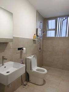 a bathroom with a white toilet and a sink at Valley Suites by WyattHomes in Kuantan