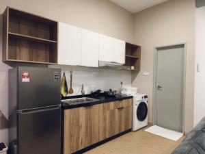 a kitchen with a refrigerator and a washing machine at Valley Suites by WyattHomes in Kuantan