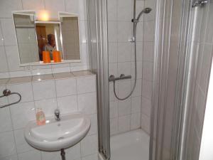 a bathroom with a shower and a sink and a shower at Hotel Klappenburg in Hannover
