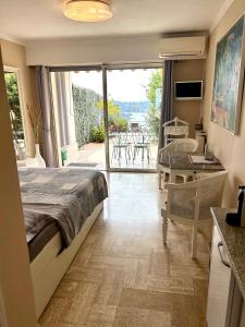 a bedroom with a bed and a balcony with a table at Studio Leopolda in Villefranche-sur-Mer