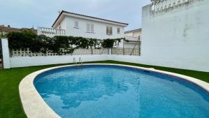 una gran piscina azul frente a una casa blanca en Casas La Vinya I, en L'Escala