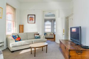 - un salon avec un canapé et une télévision dans l'établissement Roxburgh House Apartments, à Hobart