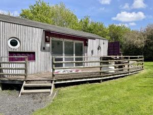 a small house with a fence around it at Purple CargoPod at Lee Wick Farm Cottages & Glamping in Clacton-on-Sea