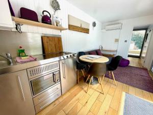 a kitchen with a table and some chairs in it at Purple CargoPod at Lee Wick Farm Cottages & Glamping in Clacton-on-Sea
