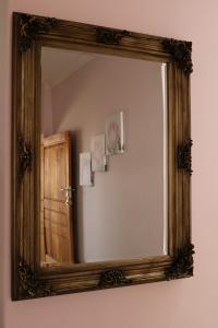 a mirror with a wooden frame on a wall at Bela Valley Guest House in Bela-Bela