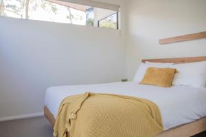 a bedroom with a white bed and a window at Villa View in Halls Gap