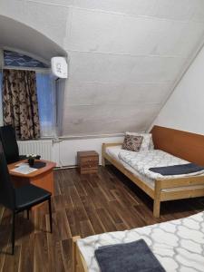 陶陶巴尼奧的住宿－羅曼蒂克艾滕姆酒店- 潘茲奧，客房设有一张床、一张桌子和一把椅子。