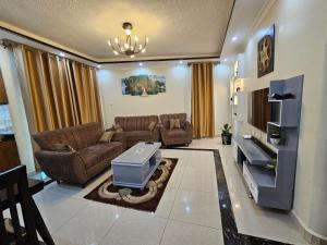 a living room with a couch and a tv at Rare APT for solo and couple Travellers in Kampala