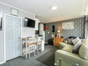 a living room with a couch and a table and a kitchen at 98 Cherry Park in Skegness