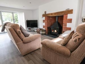 a living room with two chairs and a fireplace at Cae Iocyn in Wrexham