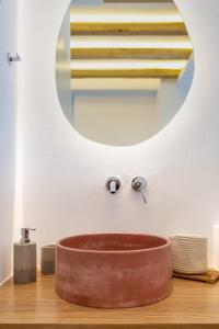 a bathroom with a copper sink and a mirror at Vivere Luxury Suites in Pera Gyalos