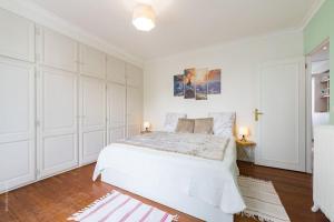 ein weißes Schlafzimmer mit einem großen Bett und weißen Schränken in der Unterkunft Somptueuse maison- Piscine-Sauna-15 personnes - Calme in Bois-Colombes
