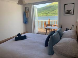 a person laying on a bed in a bedroom with a view at Cottage on the Loch in Arrochar