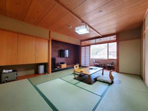 sala de estar amplia con mesa y cocina en Hotel Silk Onsen Yamabiko en Toyooka
