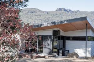 a white garage with a roof with mountains in the background at Villa View in Halls Gap