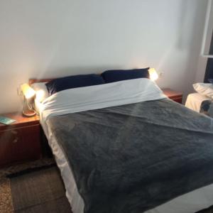 um quarto com uma cama grande com duas luzes em Mar y castillo em Cullera