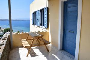 uma porta azul numa varanda com uma cadeira de madeira em Sea View Luxury Maisonette em Kapótidhes