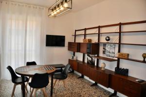 een woonkamer met een tafel en stoelen en een televisie bij M.Aurelio (Nolo) Black & White in Milaan
