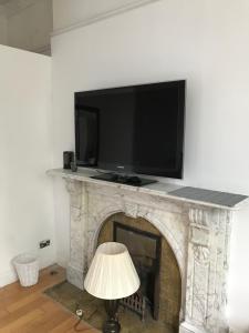 a flat screen tv sitting on top of a fireplace at Budget room en-suite 8mins walk to Singleton Hospital, R3 in Sketty