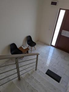 - une chambre avec deux chaises, une table et une porte dans l'établissement Samaras Apartments in Kamena Vourla, à Kamena Vourla