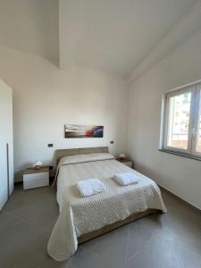 ein weißes Schlafzimmer mit einem Bett und einem Fenster in der Unterkunft Pepe Apartments in Gragnano