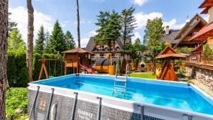 a pool in the backyard of a home with a house at Aparthotel Delta Zakopane in Zakopane