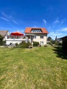 a white house with a red roof and a yard at Ferienwohnungen Wotan in Thale
