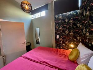 a bedroom with a pink bed with a pink blanket at Residentie de Eikhof in Hengelo